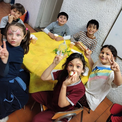 Niños compartiendo hot dos en el comedor
